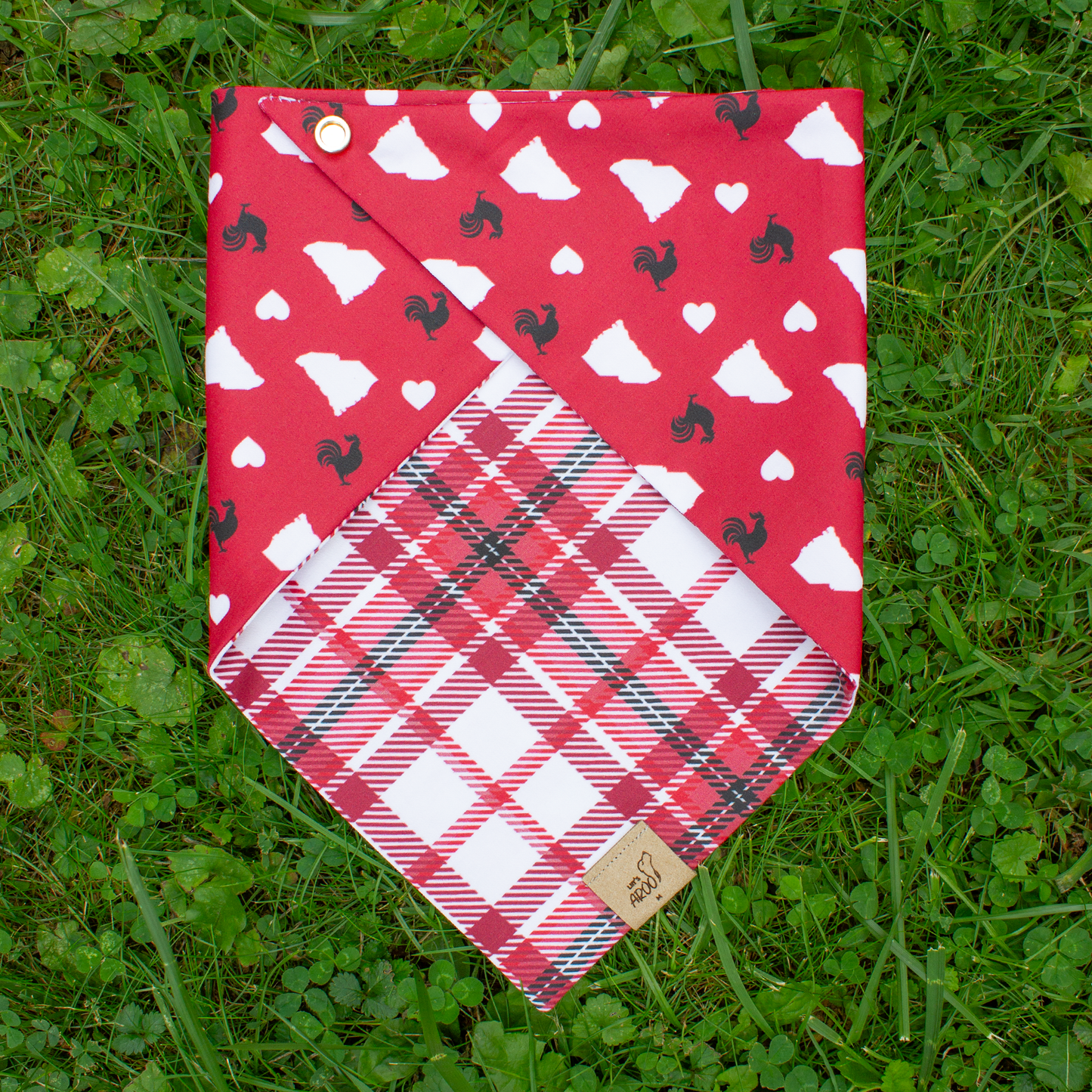 Red bandana with rooster pattern on grass